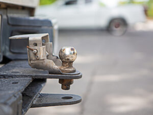 Close-up of a sturdy trailer hitch with a ball mount attached to the back of a vehicle, illustrating safe towing practices and proper hitch selection.