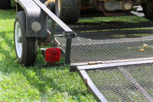 Close-up of a steel utility trailer with a mesh deck and durable frame, showcasing benefits of steel trailers for heavy-duty hauling.